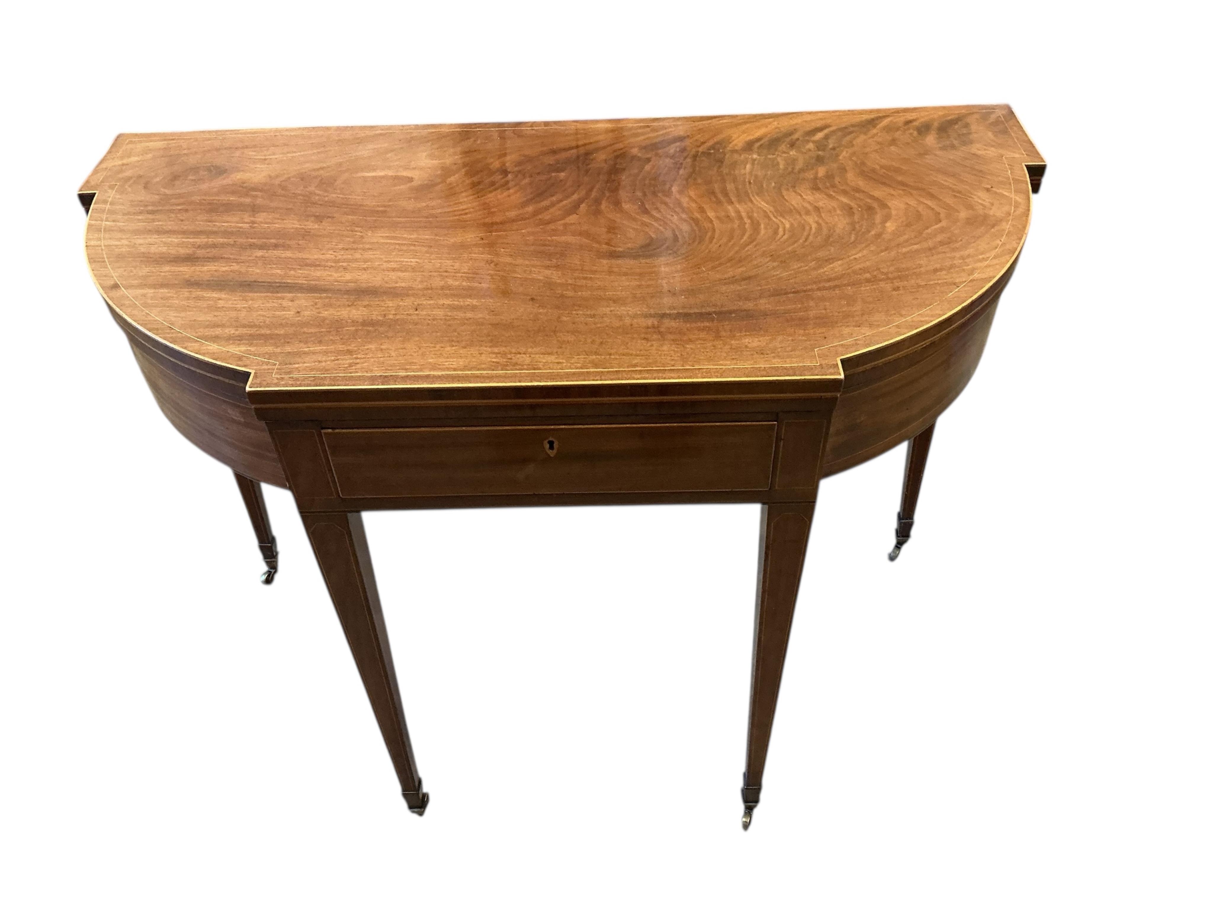 A George III boxwood strung mahogany breakfront folding tea table with frieze drawer, width 101cm, depth 47cm, height 74cm